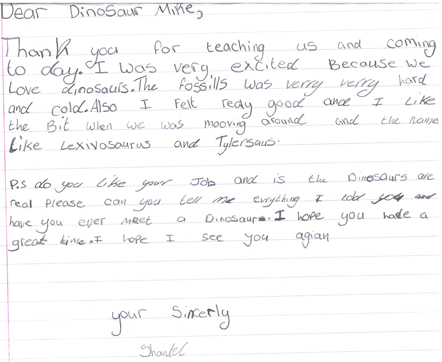 Children compose thank you letters after dinosaur workshop.