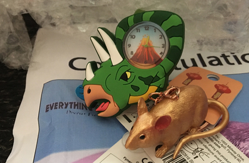 A Triceratops watch and a Mojo Fun lucky golden rat.
