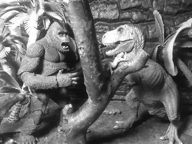King Kong is confronted by Tyrannosaurus rex.