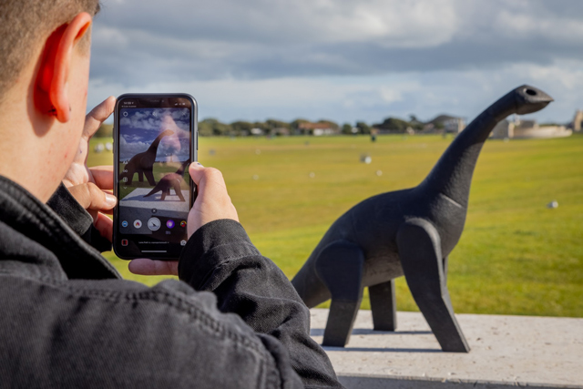 Scanning the QR code on the Southsea Common dinosaur statue
